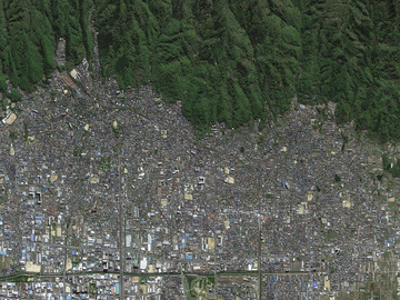 Les bâtiments, les routes et les rails d'Osaka, au Japon, rejoignent les collines boisées environnantes.